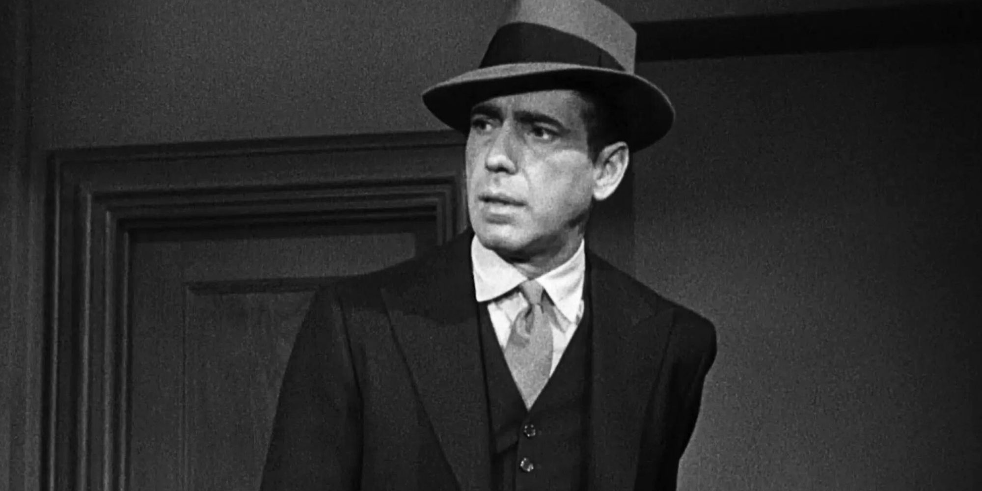 Humphrey Bogart looks serious in a suit as Sam Spade in The Maltese Falcon (1941).