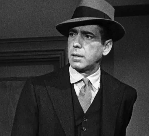 Humphrey Bogart looks serious in a suit as Sam Spade in The Maltese Falcon (1941).