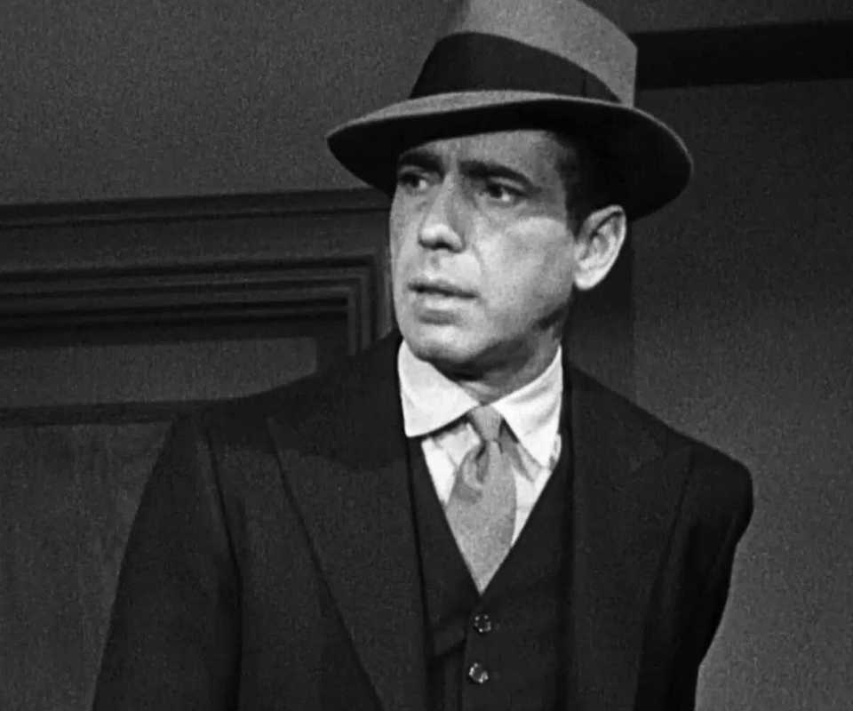 Humphrey Bogart looks serious in a suit as Sam Spade in The Maltese Falcon (1941).