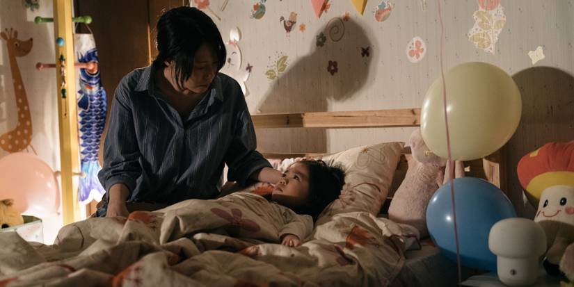 A woman tending to a child in bed in Incantation