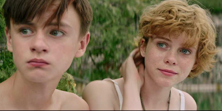 Jaeden Martell and Sophia Lillis looking to their right in It (2017).