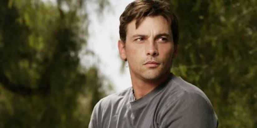 A close-up of Skeet Ulrich as Jake Green on 'Jericho,' squinting his eyes outside in a T-shirt.