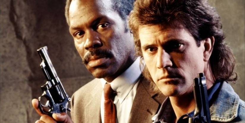 Mel Gibson and Danny Glover holding guns while looking at the camera in Lethal Weapon.
