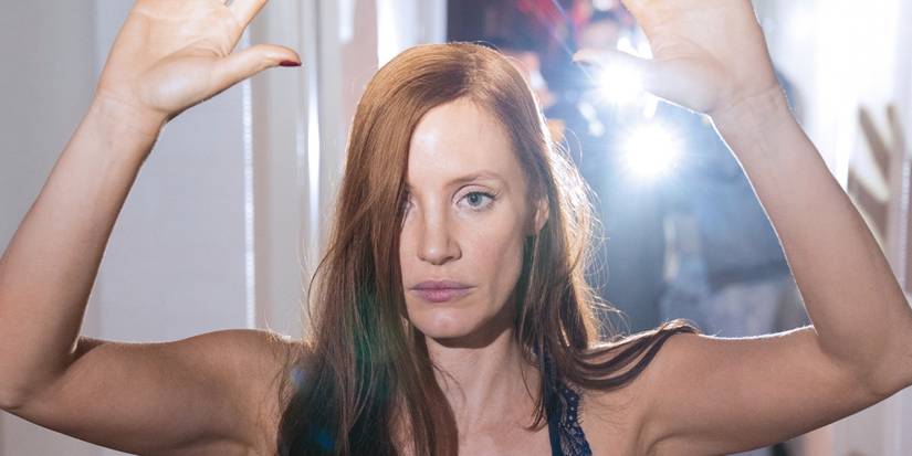 Jessica Chastain as Molly Bloom with her hands up in Molly's Game.