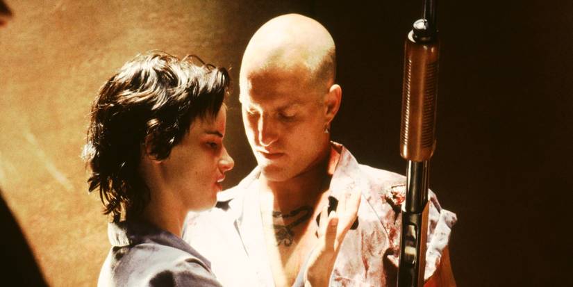Woody Harrelson and Juliette Lewis as Mickey and Mallory Knox standing close in Natural Born Killers. 