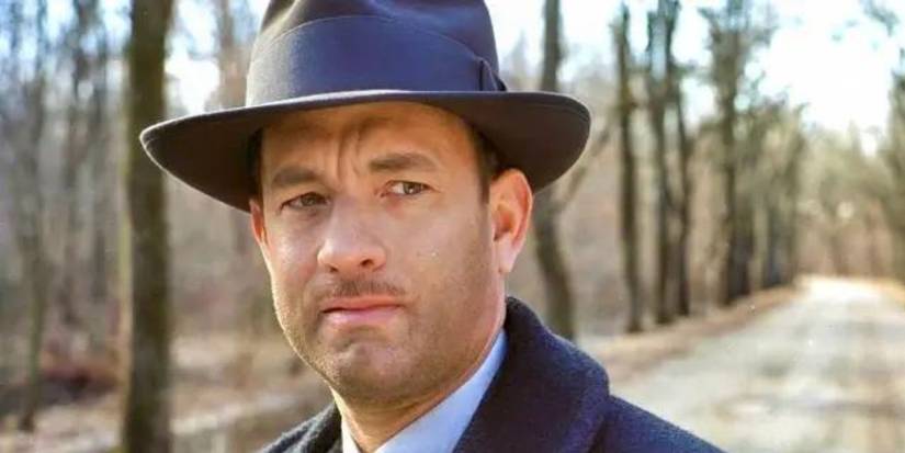 A close-up of Tom Hanks on a woodsy road outside in Road to Perdition.