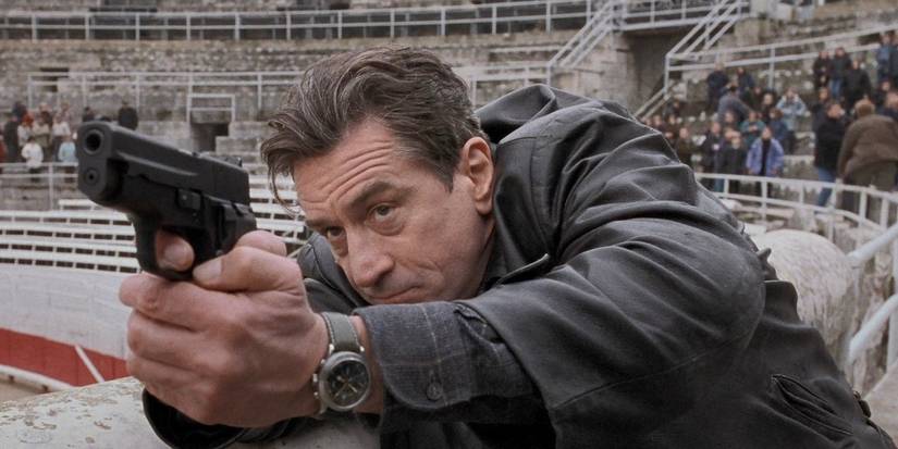 Sam (Robert De Niro) aiming a pistol at an angle in pier in 'Ronin'