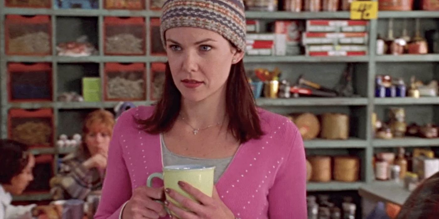 Lauren Graham as Lorelai wearing a hat & holding a coffee cup in Luke's Diner in the Gilmore Girls pilot.