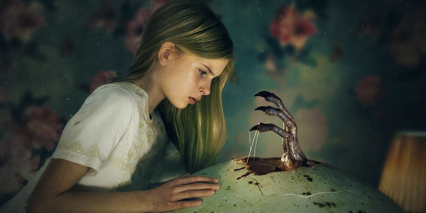 Siiri Solalinna as Tinja looking at a claw coming out of a large egg in Hatching