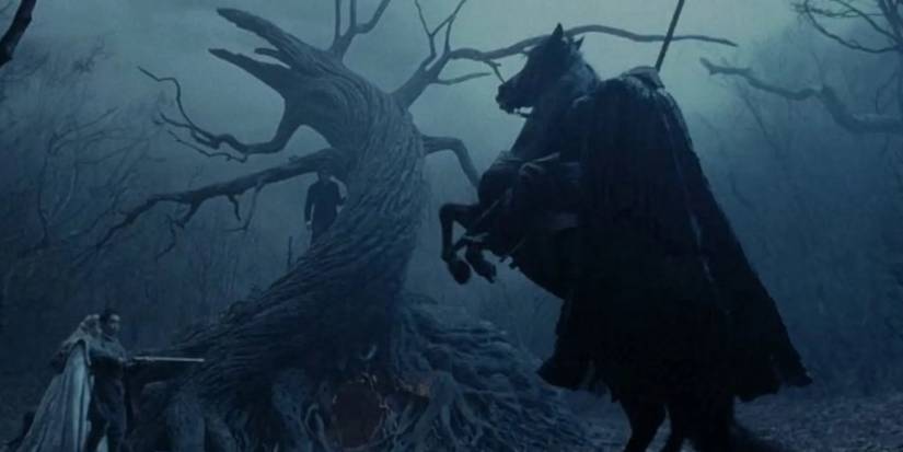 The Headless Horseman in the woods wielding a sword in front of a tree in Sleepy Hollow