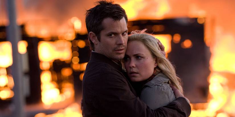 Timothy Olyphant as David Dutton holding Radha Mitchell as Judy Dutton in front of a burning city in The Crazies