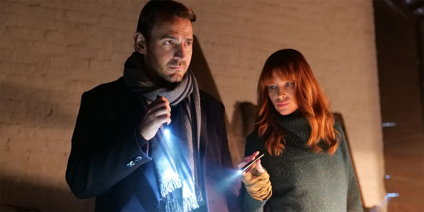 Ewan Leslie and Emma Booth holding flashlights, investigating something, in The Gloaming