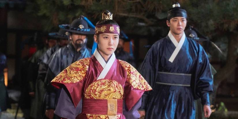 People in historical clothing stare ahead seriously in a still from the K-Drama The King's Affection.