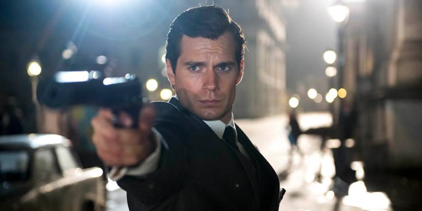 Napoleon Solo stands in a European street at night & aims his pistol in Man From UNCLE
