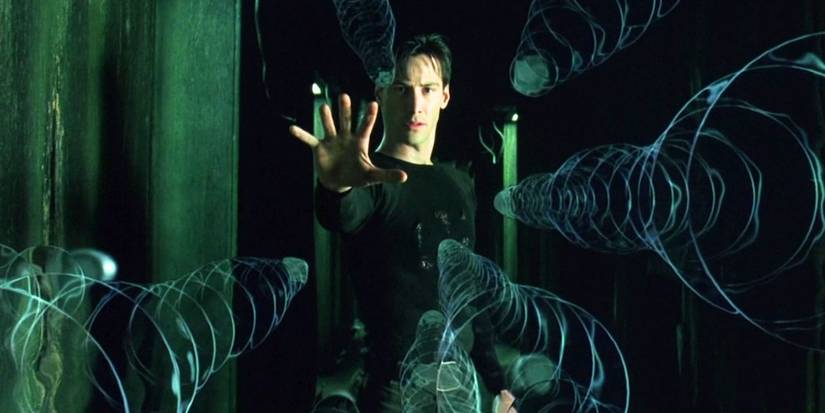Neo, played by Keanu Reeves, freezes flying bullets with his hand outstretched in The Matrix.