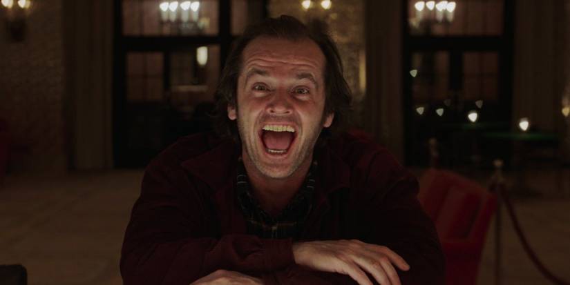 Jack sits at a table and laughs at the camera