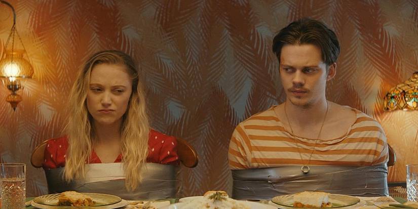 Jules and Mickey tied to their chairs at the dinner table in Villains