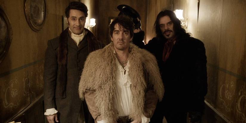 Taika Waititi, Jonathan Brugh, and Jermaine Clement standing in a hallway in What We Do in the Shadows.