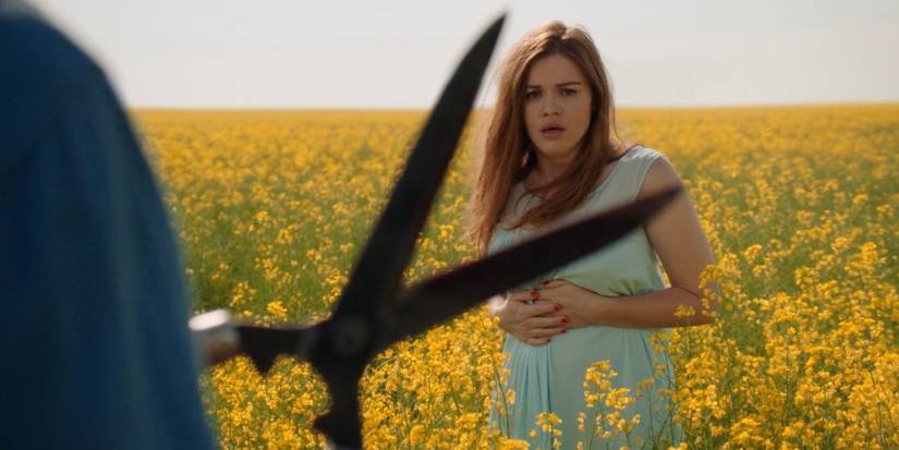 Holland Roden olhando para uma figura com uma tesoura em um campo de plantas amarelas no Canal Zero: Butcher's Block.