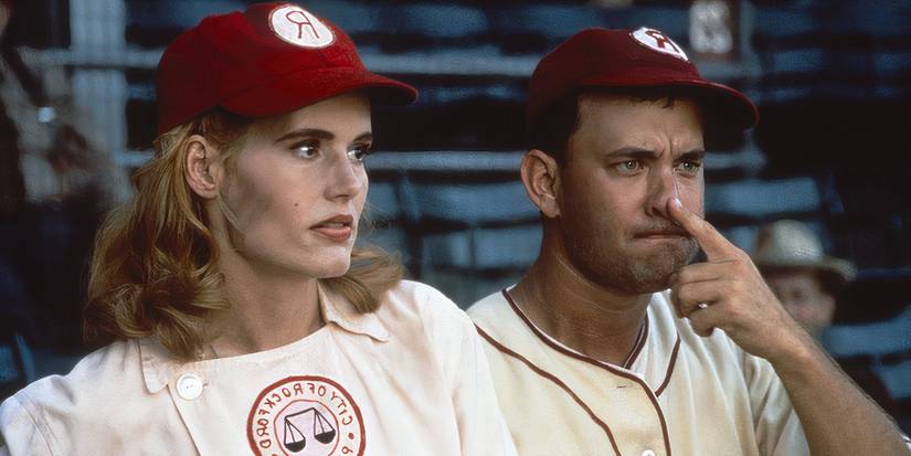 Geena Davis in a baseball uniform, Tom Hanks beside her with his finger on his nose looking angry