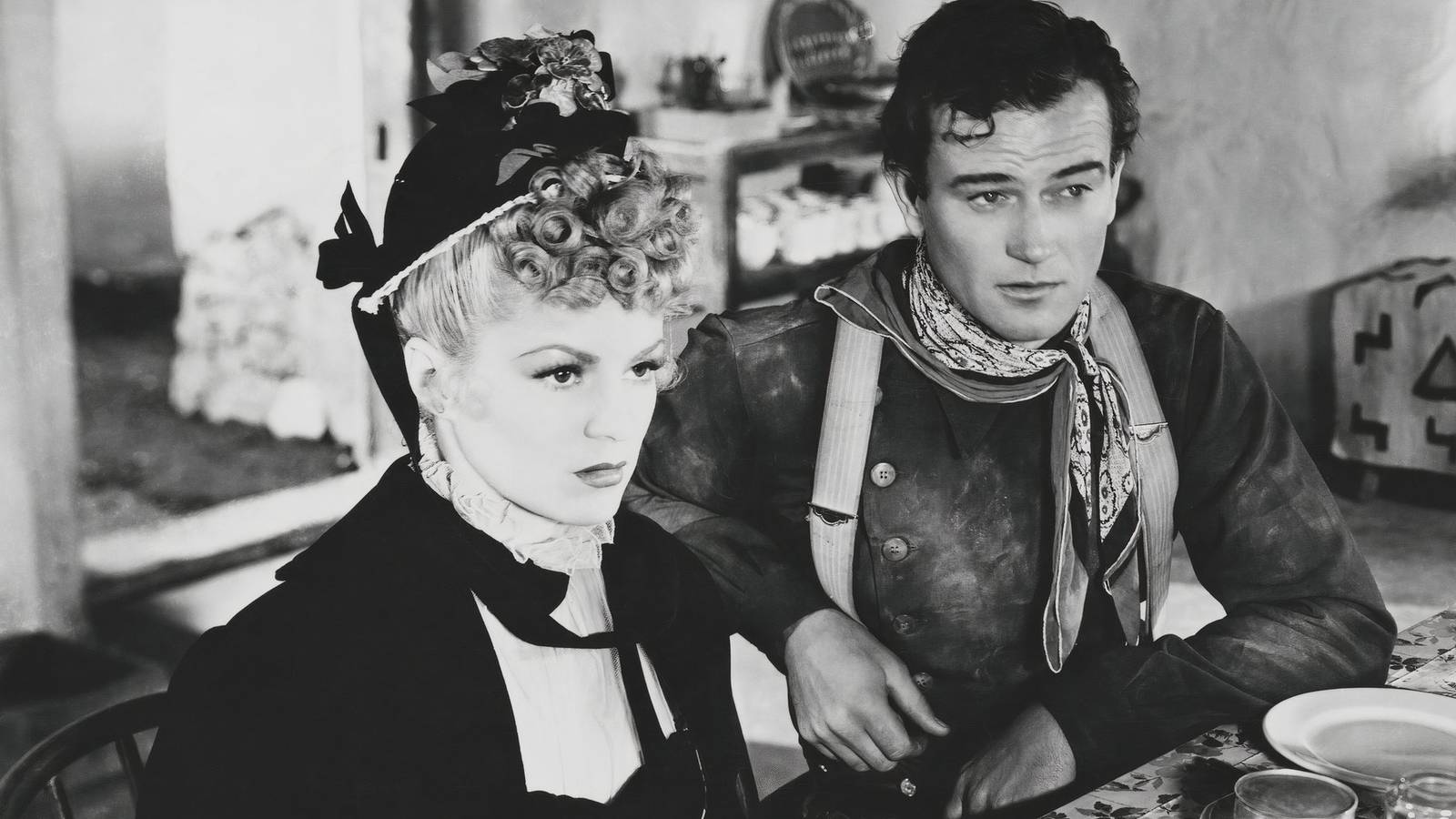Claire Trevor and John Wayne in Stagecoach sitting next to each other