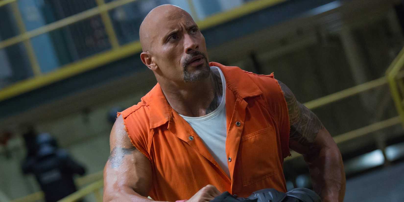 Dwayne Johnson in an orange jumpsuit in a prison looking confused in The Fate of the Furious.