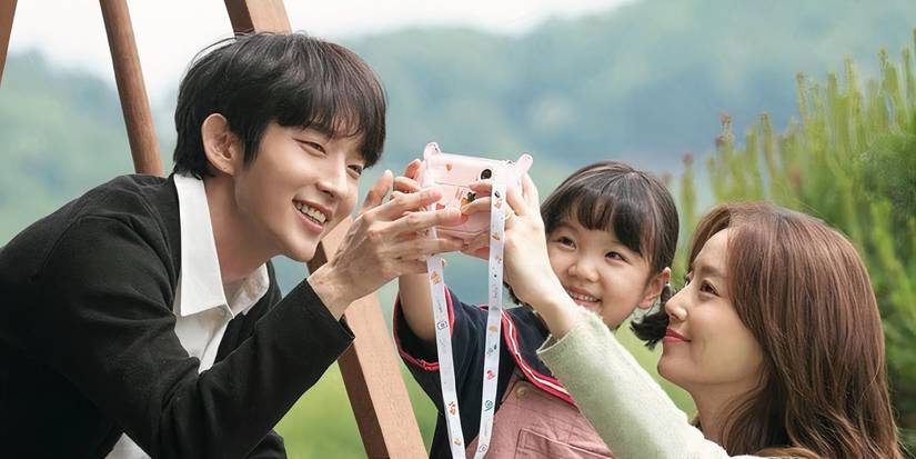 A man, woman, and small young girl take a photo together and look happy in Flower of Evil.