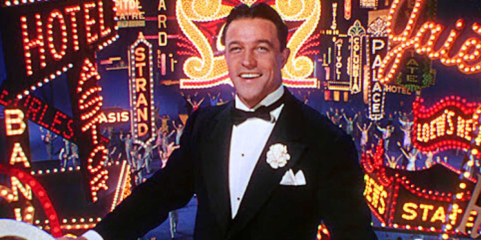 Gene Kelly as Don Lockwood standing in front of a bunch of lit up signs in Singin' in the Rain (1952)