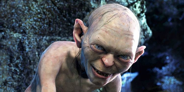 Gollum, played by actor Andy Serkis, crouched down smiling menacingly in Lord of the Rings: The Two Towers