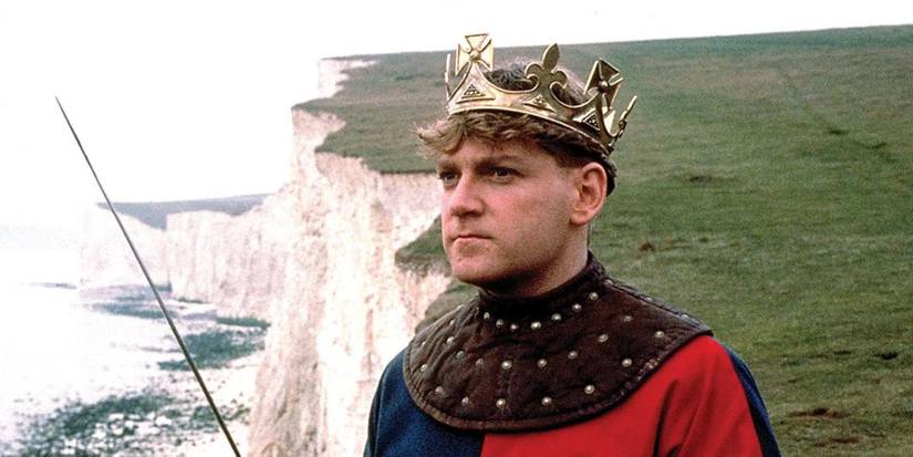 Henry V looking to the distance while standing on a cliff holding a sword in Henry V