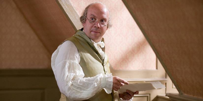 Paul Giamatti glancing up from a handful of papers in HBO's John Adams.