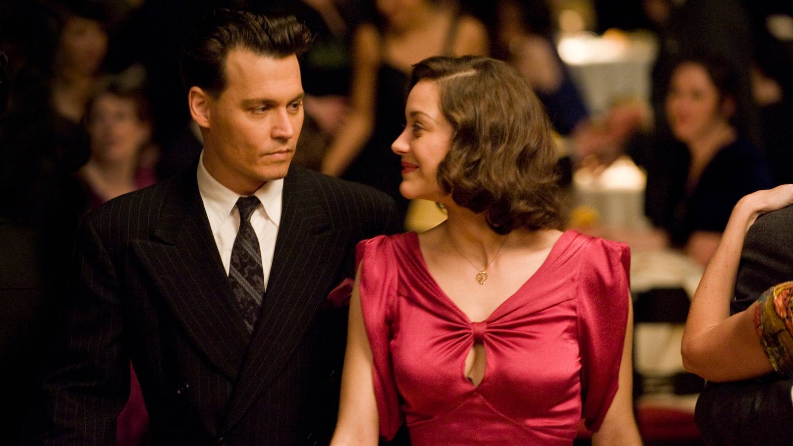 Johnny Depp and Marion Cotillard look at each other on the dance floor in Public Enemies. 