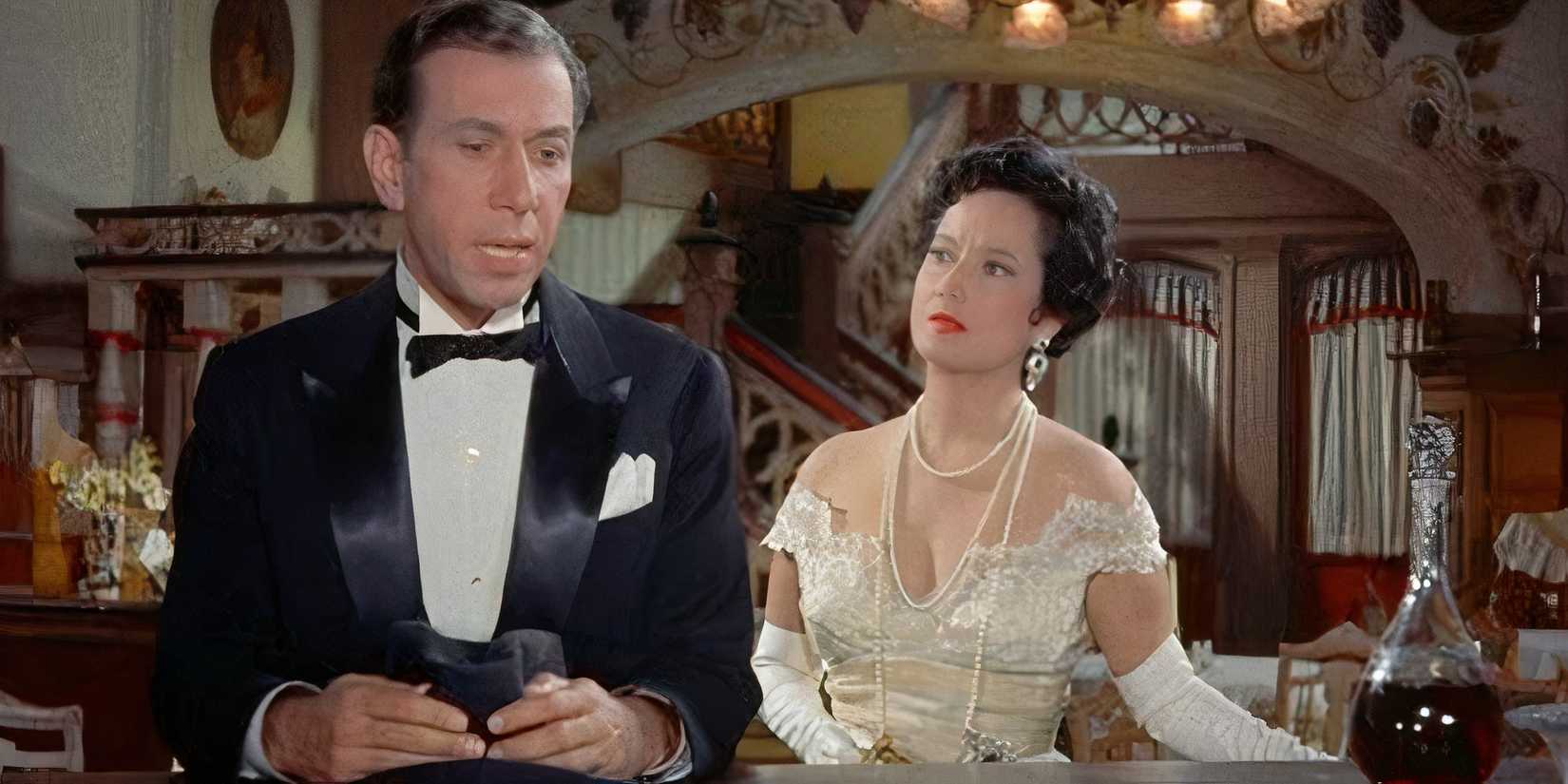 Jose Ferrer stands in front of a bar counter while Merle Oberon stands behind him in Deep in My Heart