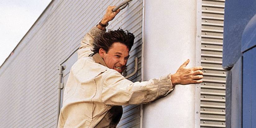 Kurt Russell as Jeff Taylor hanging on the side of a truck in Breakdown