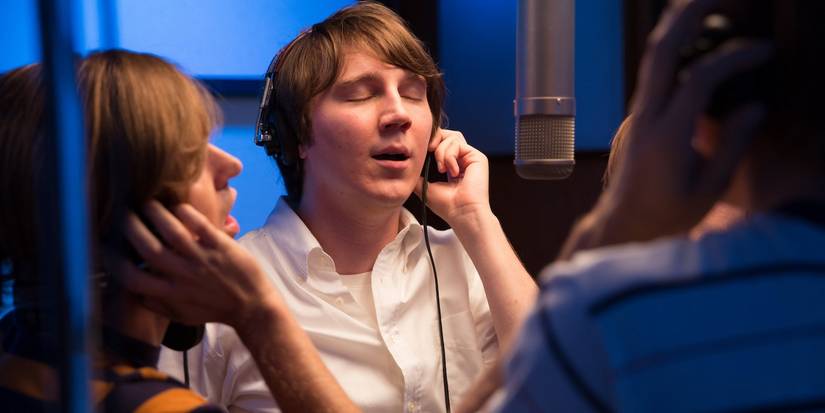 Paul Dano as Brian Wilson wearing a headset and recording in a studio with others in Love & Mercy.