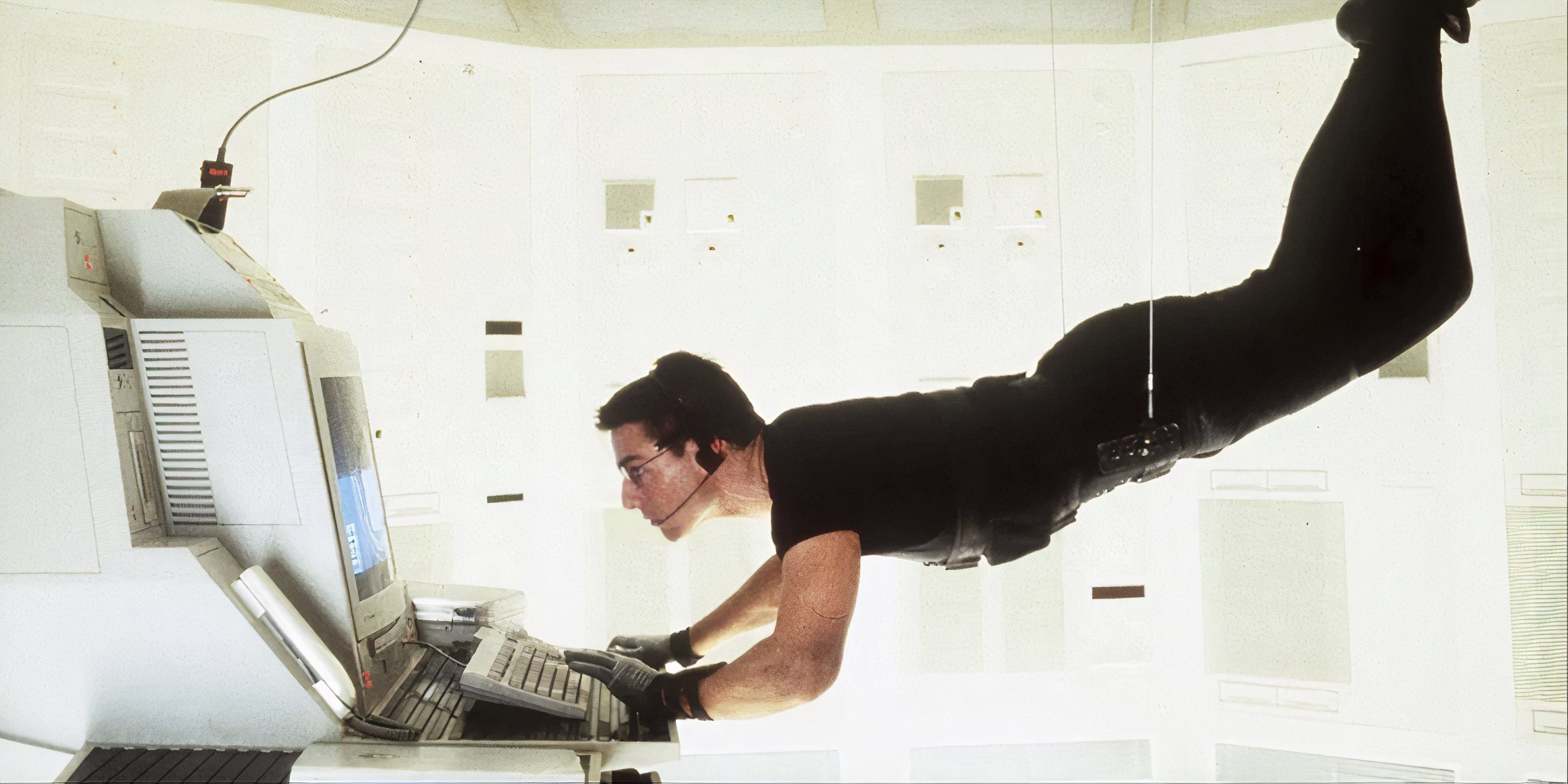 Tom Cruise hacking into a computer while being suspended by cables in Mission: Impossible