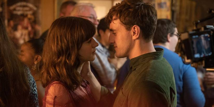 Daisy Edgar-Jones and Paul Mescal as Marianne and Connell staring at each other at a party in Normal People.