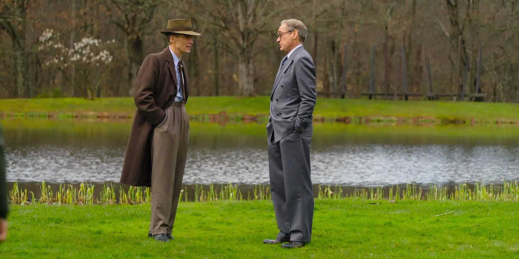 Robert Oppenheimer and Lewis Strauss confer on the grass at Princeton University in Oppenheimer