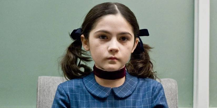 Isabelle Fuhrman as Esther sitting in a chair with pigtails looking blankly ahead in Orphan.