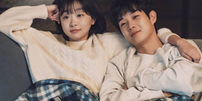 The two main cast members cuddling on a couch together in Our Beloved Summer.