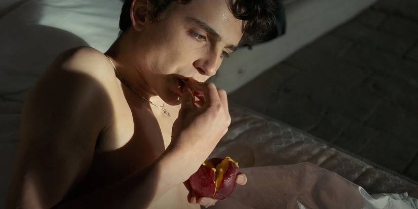 A shirtless Elio eating a peach in Call Me by Your Name (2017).