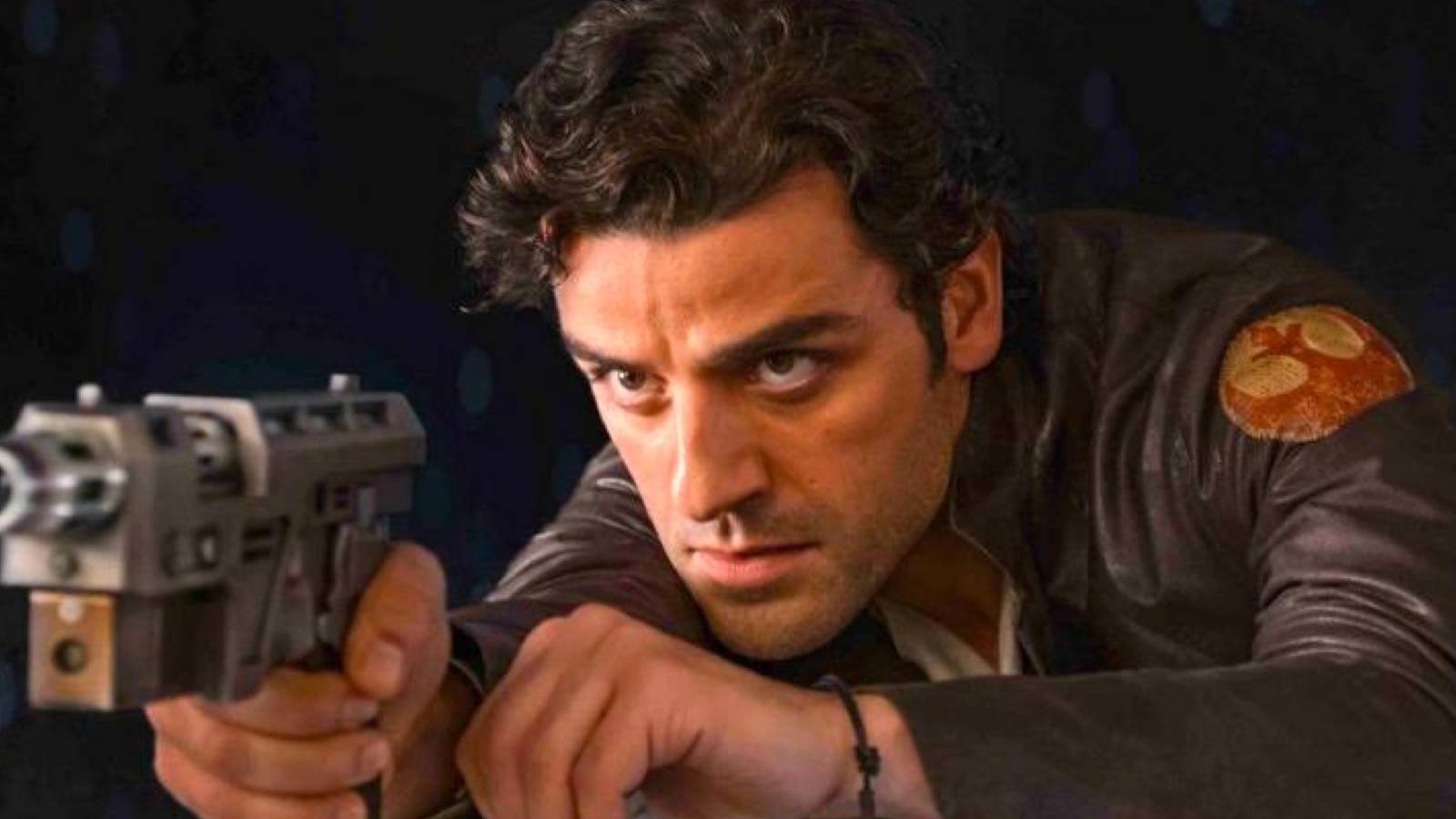 Poe Dameron (played by actor Oscar Isaac), readies his blaster with a tense expression in Star Wars: Episode VIII - The Last Jedi.