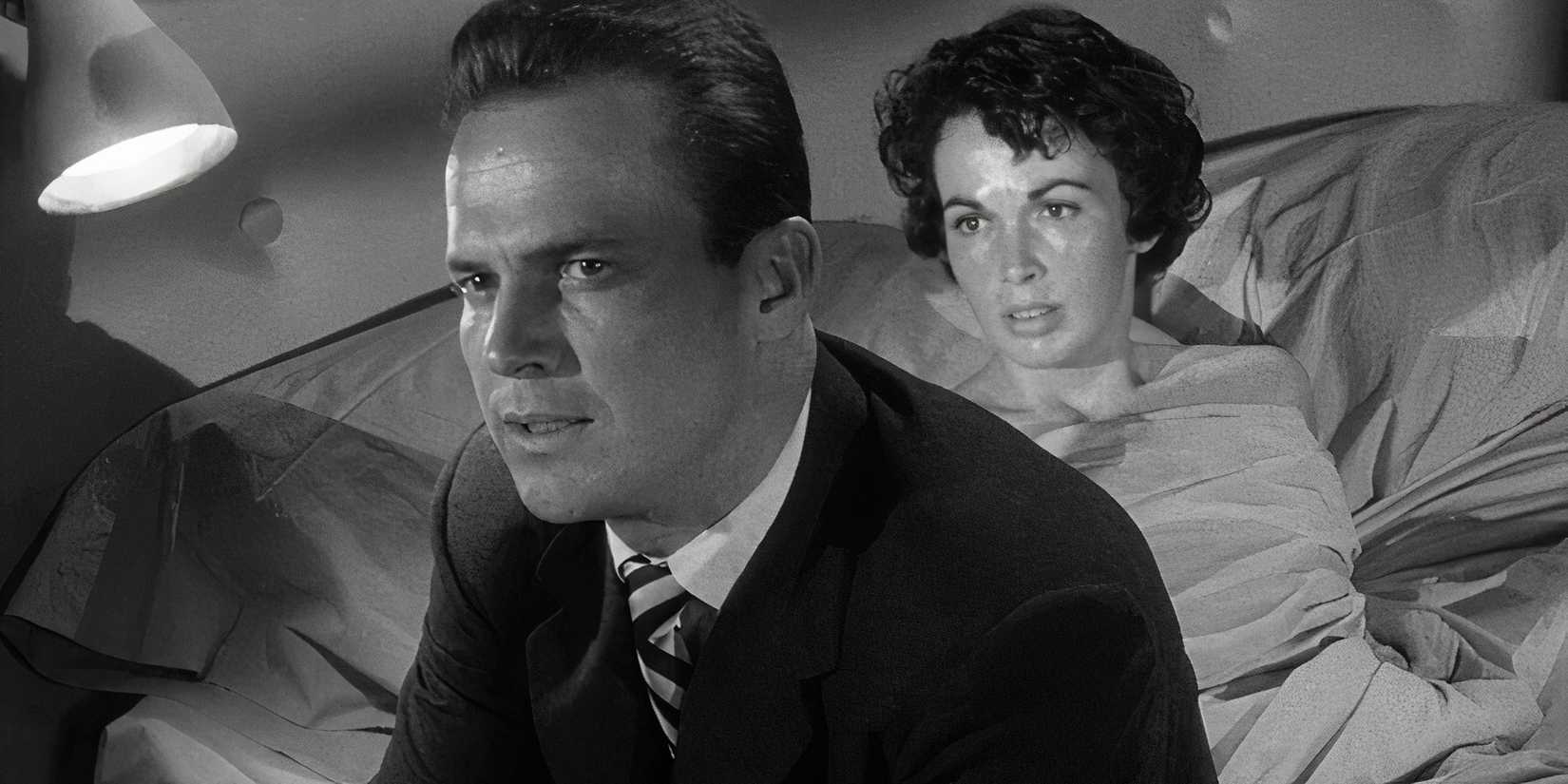 Ralph Meeker sitting on the edge of a bed with Maxine Cooper sitting up in the bed behind him in Kiss Me Deadly (1955)
