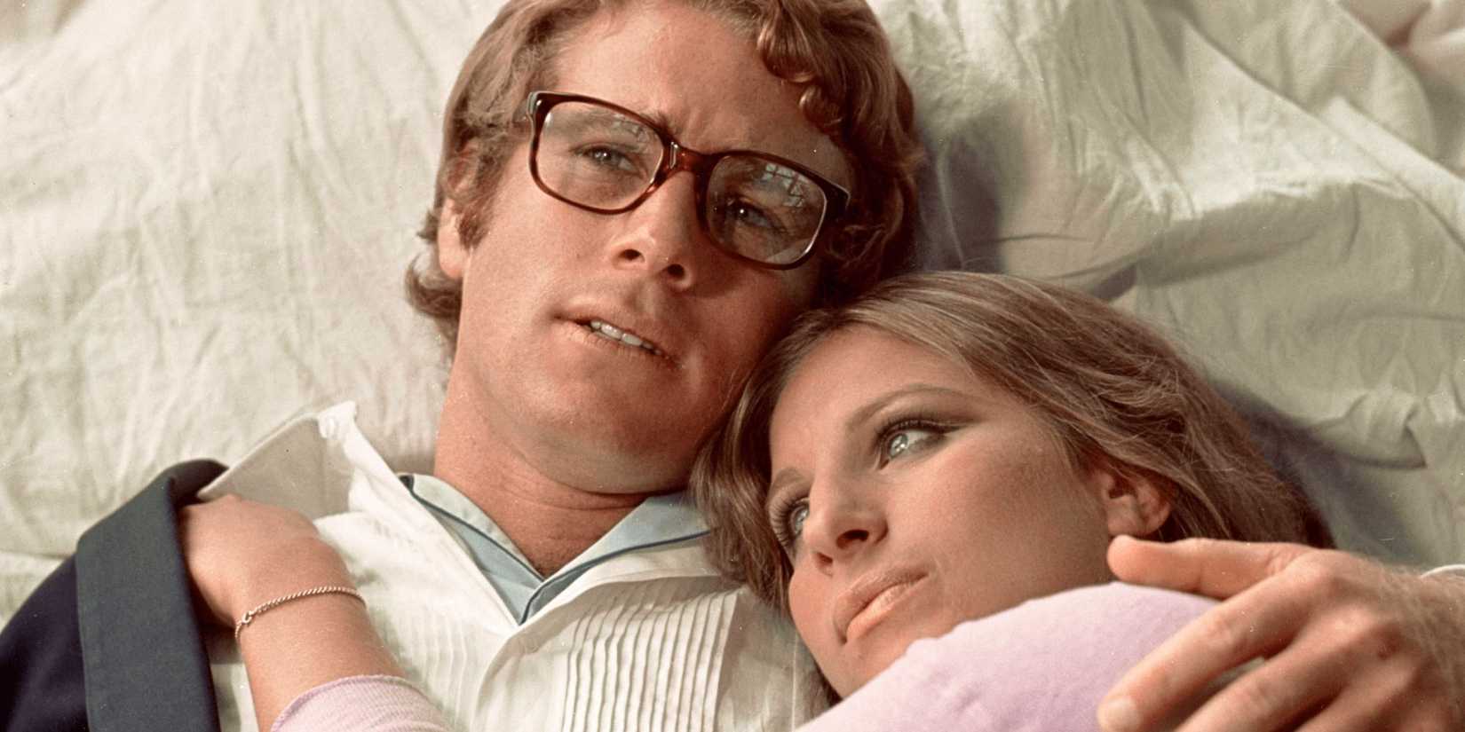 Ryan O'Neal holding Barbra Streisand while lying down together in What's Up, Doc, 1972.
