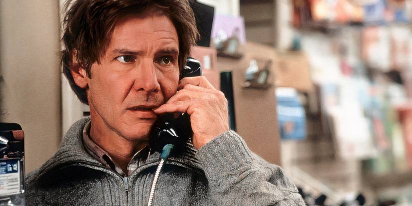Harrison Ford as Richard Kimble, talking on a payphone and wearing a grey sweater in The Fugitive.
