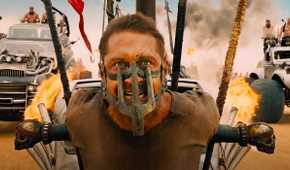 Max, played by Tom Hardy, strapped to the front of a vehicle with mask on in Mad Max: Fury Road (2015).