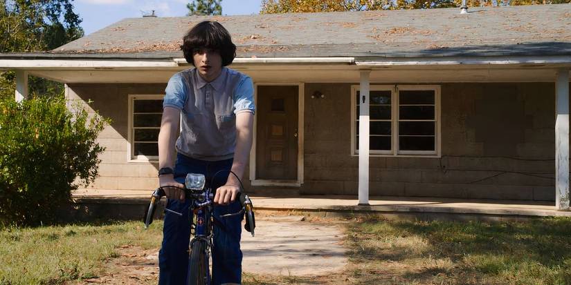 Mike (Finn Wolfhard) leaving the Byers house on a bike in Stranger Things