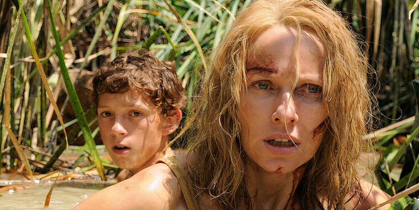 Naomi Watts and Tom Holland as Maria and Lucas Bennett, injured and wading through water in The Impossible.