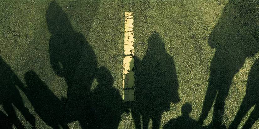 shadows of people on a road on the book cover of Stephen King's 'The Long Walk'