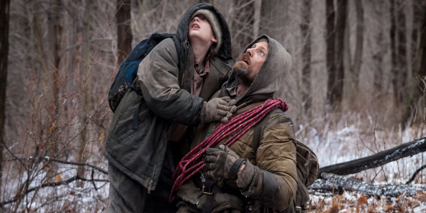 Viggo Mortensen and Kodi Smit-McPhee in a forest looking up in The Road
